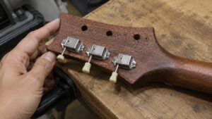 ギターのヘッドに新しいペグを3つ取り付けた交換途中の状態